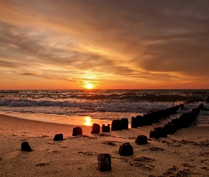 Plaża, Zachód słońca, Fale, Morze, Falochron, Chmury, Niebo, Pale, Piasek