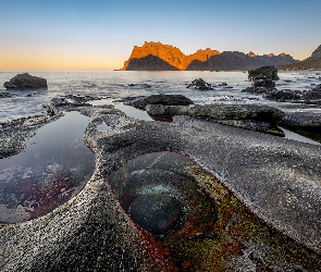 Morze, Niebo, Norwegia, Głazy, Chmury, Uttakleiv Beach, Lofoty, Zachód słońca, Kamienie, Góry, Skały