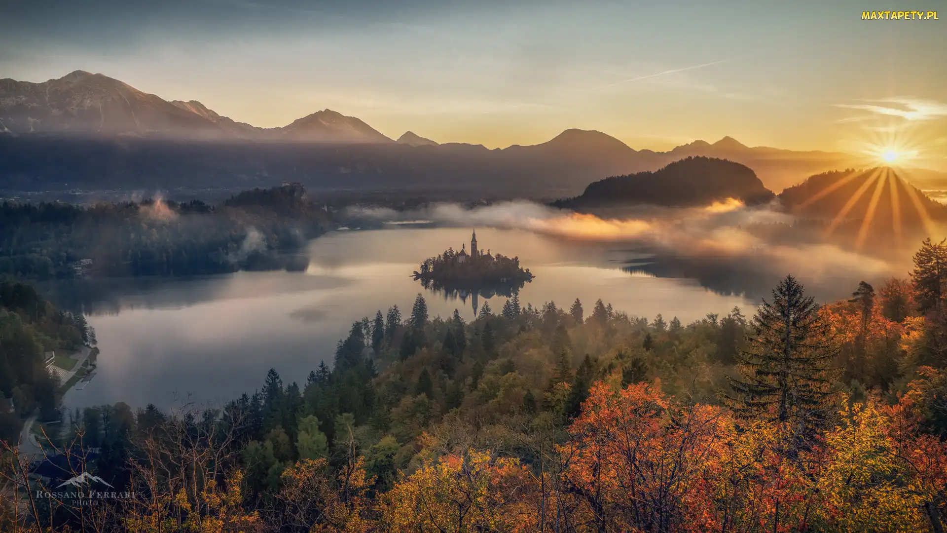 Słowenia, Jesień, Chmury, Mgła, Drzewa, Promienie słońca, Wyspa Blejski Otok, Góry Alpy Julijskie, Jezioro Bled