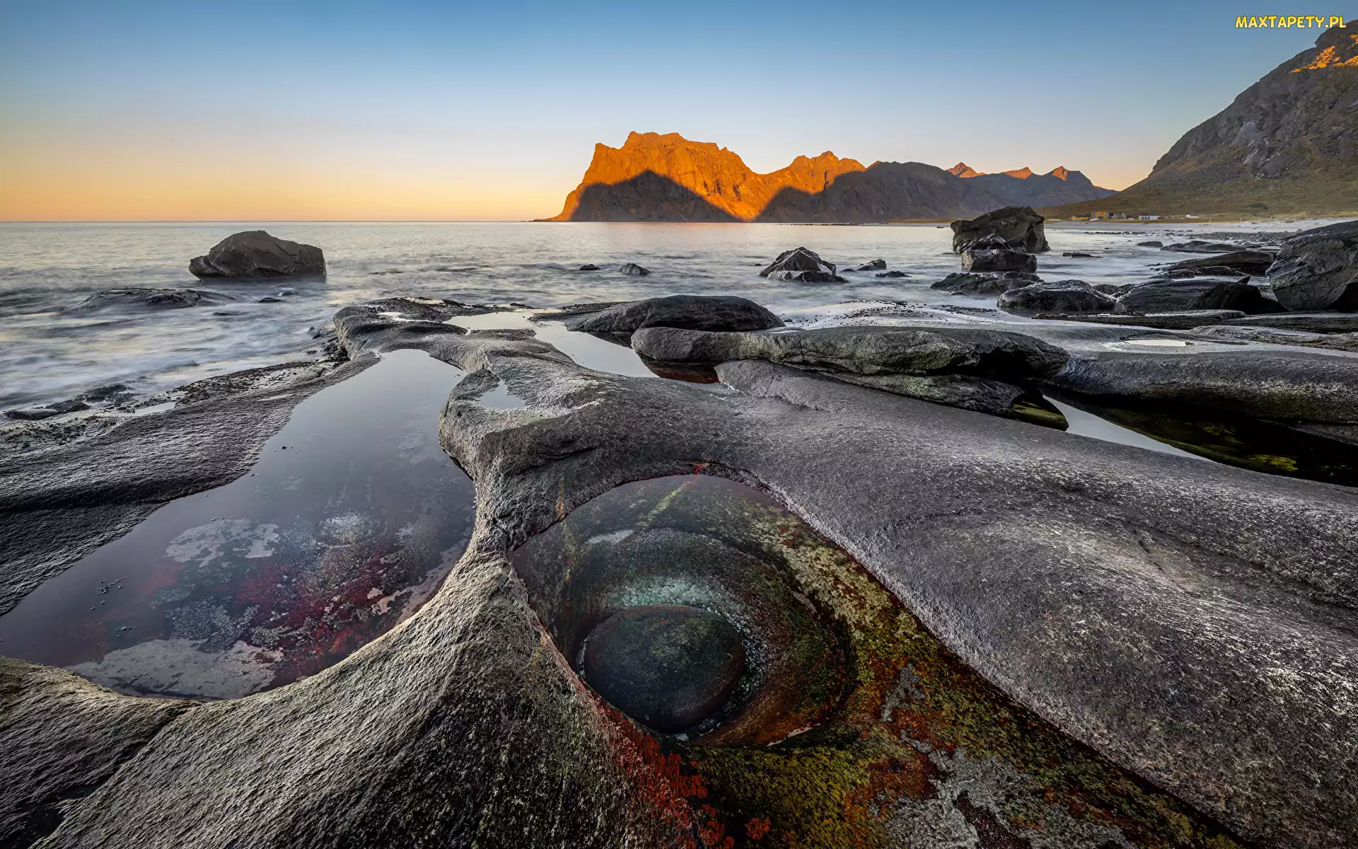 Morze, Niebo, Norwegia, Głazy, Chmury, Uttakleiv Beach, Lofoty, Zachód słońca, Kamienie, Góry, Skały