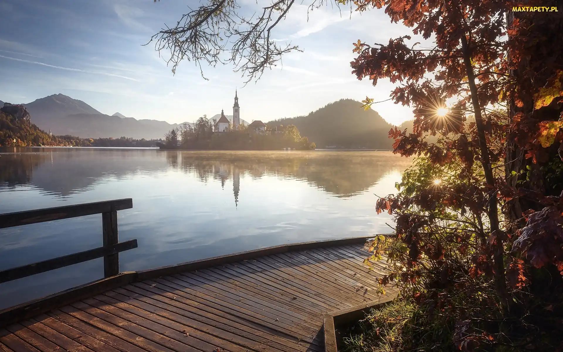 Słowenia, Promienie słońca, Wschód Słońca, Drzewa, Pomost, Góry Alpy Julijskie, Jezioro Bled, Wyspa Blejski Otok, Kościół Zwiastowania Marii Panny